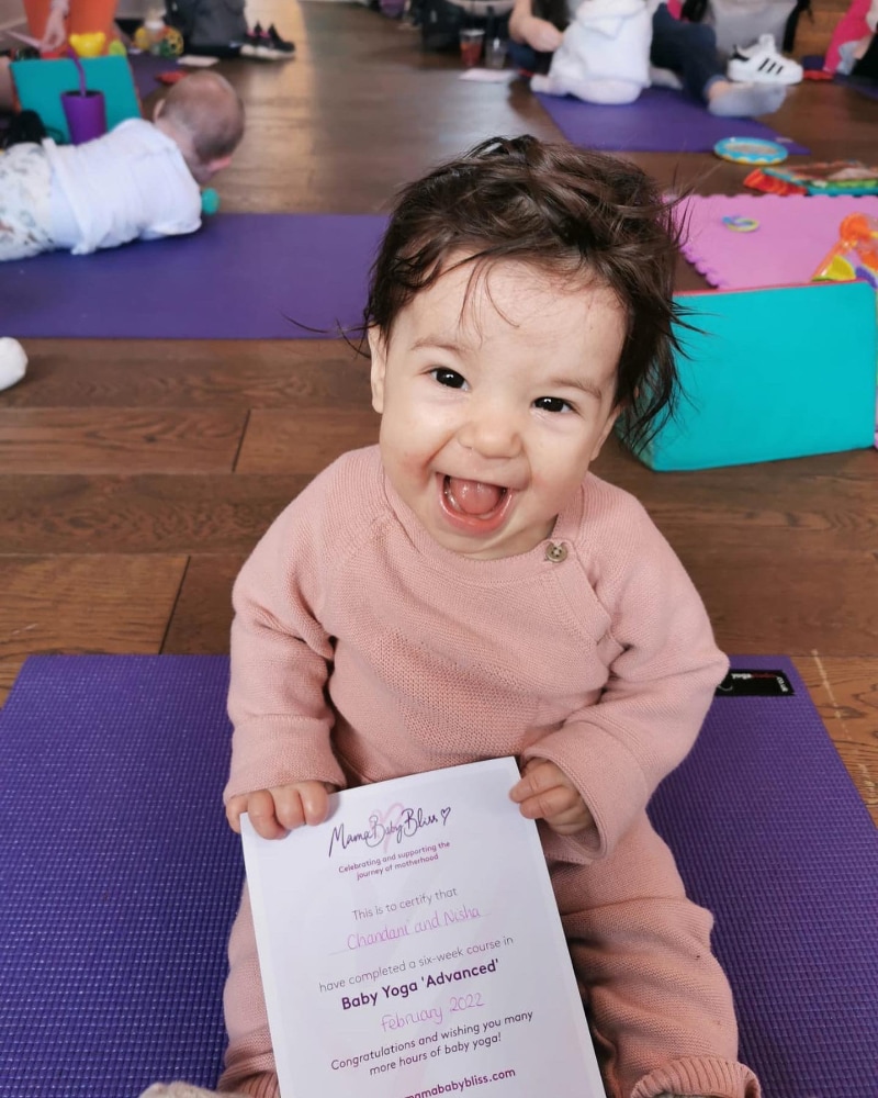 Child holding her baby yoga certificate